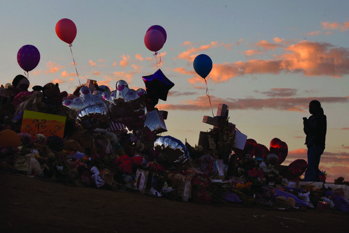 A mourner pays tribute to those killed in the massacre at a movie screening of The Dark Night Rises in Aurora, CO. (Courtesy of Mark Boster/LA Times/MCT)
