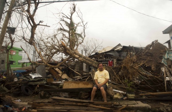 A resident sits on debris in typhoon-hit Leyte Province, Nov. 12, 2013. (Lui Siu Wai/Zuma Press via MCT)