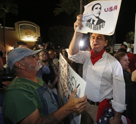 President Obama supporter Peter Bell, right, debates with anti-Obama demonstrators at Versaille's Restaurant in Miami on Wednesday, Dec. 17, 2014, after President Obama's decision to normalize relations between Cuba and the United States. (AL DIAZ/Miami Herald/TNS)