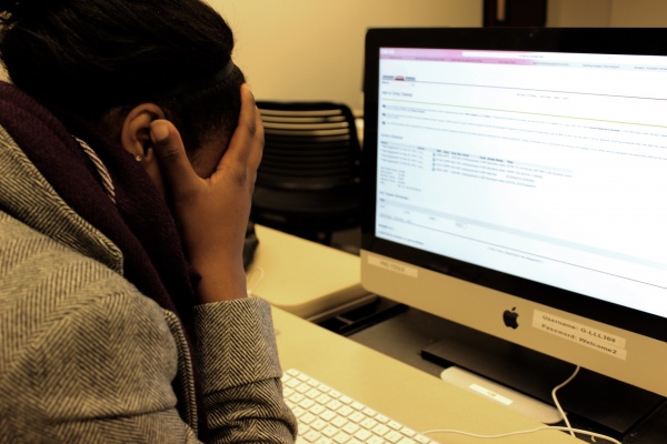 Fordham student Catrina L. hangs her head in frustration in a computer lab at Lincoln Center for the Spring semester. (PHOTO ILLUSTRATION BY ZANA NAJJAR/ THE OBSERVER)