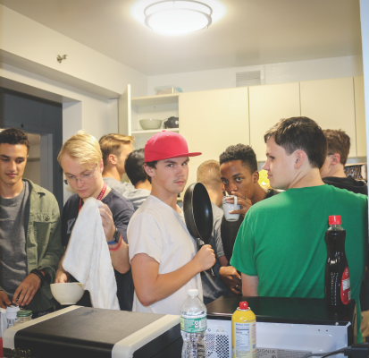 Freshmen in a nine-person suite cook dinner in close quarters. (Matt LaBarbera/The Observer)