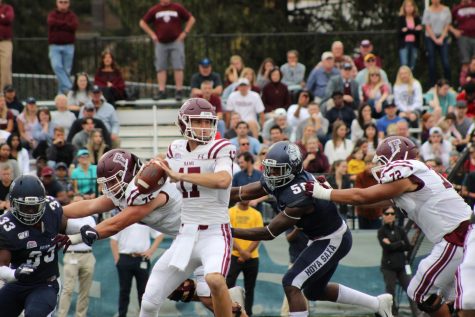 Tim DeMorat, FCRH ’22, steps back to throw as Georgetown’s defense breaks through the offensive line.