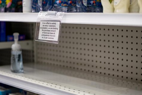 An empty shelf formerly holding hand sanitizer with a sign that limits hand sanitizer and antibacterial products to 3 per customer