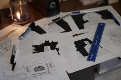 Storyboards of Koty Vooys latest film are spread out across a table with pens and a ruler on top of them.