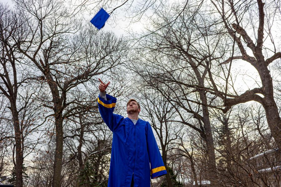 a+student+wearing+a+blue+graduation+gown+and+throwing+a+cap+into+the+air