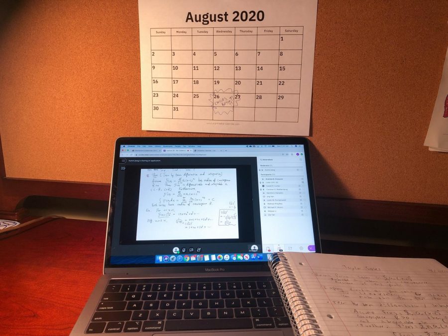 an+open+laptop+in+front+of+a+wall+calendar