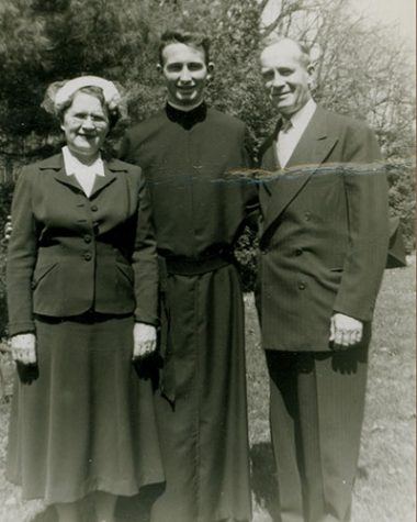 Black and white family photo with a young Fr. O'Hare in the center, his mother to his right, and his father to his left