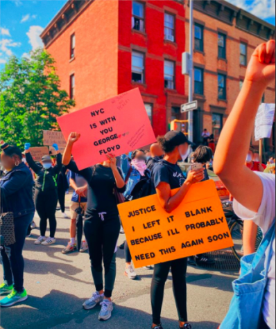 Protestors in NYC holding signs reading "NYC is with you George Floyd" and "Justice [blank] I left it blank because I'll probably need this again soon"