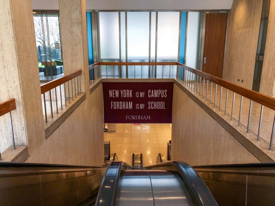 banner with the school slogan, "new york is my campus, fordham is my school," from the top of an escalator