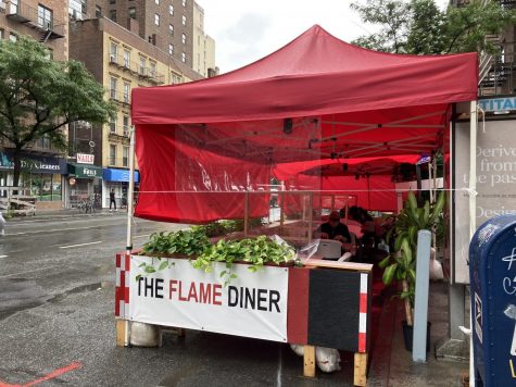 red tent with sign that says "the flame diner" on a street