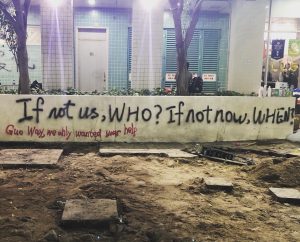 a wall with graffiti in Hong Kong reading if not us, WHO? If not now, WHEN? below is more graffiti reading Guo Way, we only wanted your help