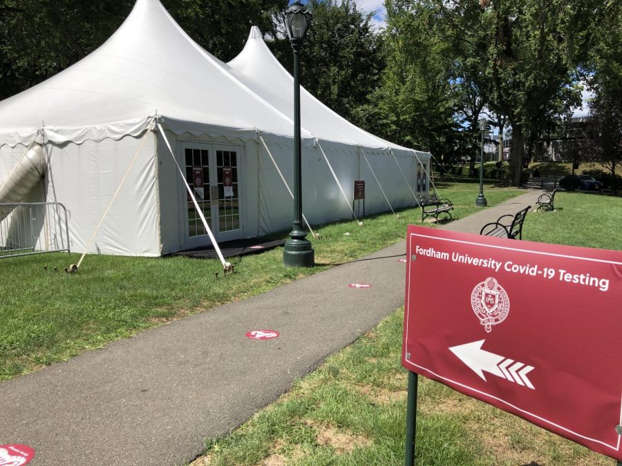 picture of white tents with a red sign in front indicating the tents are for coronavirus testing
