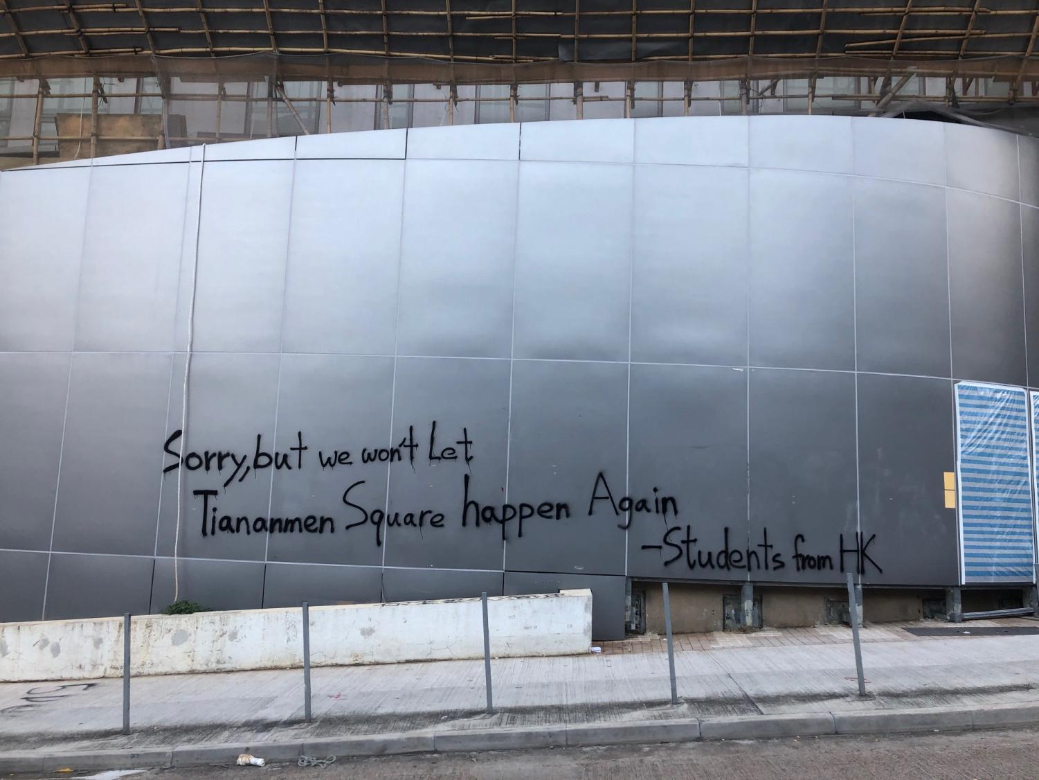 graffiti on a building reading "Sorry, but we won't let Tiananmen Square happen again -students from HK"