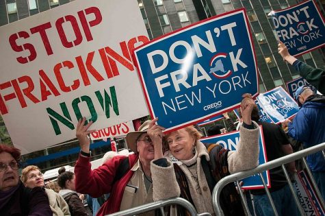 protestors holding up signs against fracking