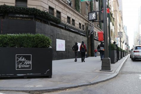 the storefront of Saks Fifth Avenue entirely covered in black boards