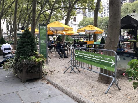 sign reminding people to social distance while in bryant park's spaces