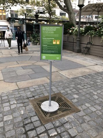 sign with social distancing reminders in one of bryant park's stone spaces