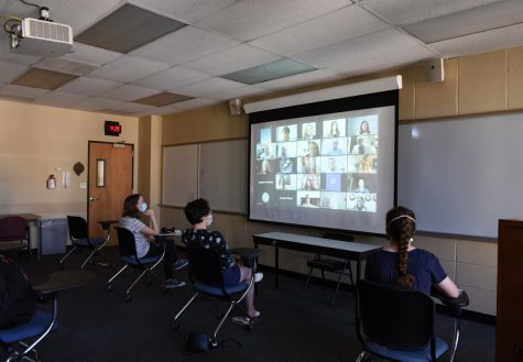 students in a classroom watching a hybrid class on zoom. spring 2021 registration will include online and hybrid classes.