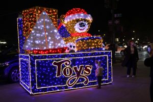 A giant box of toys on the sidewalk of Fifth Avenue, which is part of a collection of similar light-up decorations lining the street.