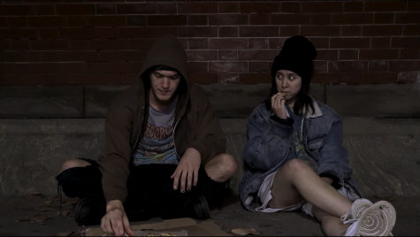 two actors sitting against a brick wall eating french fries as part of the show nineveh for the studio fest