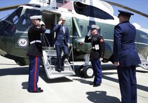 Biden steps off of Marine One while saluting the soldiers