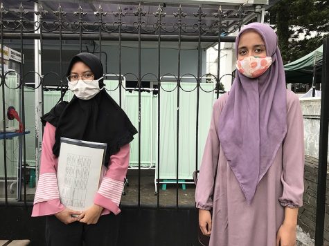 photo of two vaccine volunteers hoping to achieve immunity. both have face masks and head coverings on.