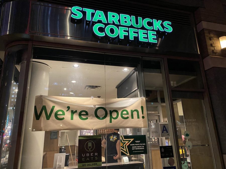 photo of a new york starbucks window with a sign saying were open in the window