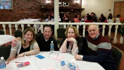 Laura Greeney sits at a restaurant table with her family members