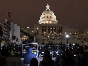 protestors gather at night outside the US Capitol building as police barricade the front steps