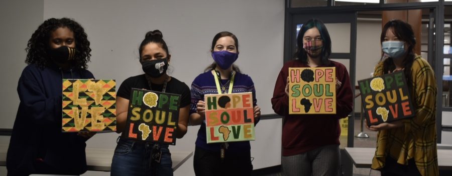 five student attendees of the Black History Month paining event hold up their artworks