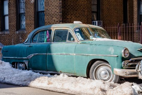 a turquoise vintage car in little odessa in a snow mound
