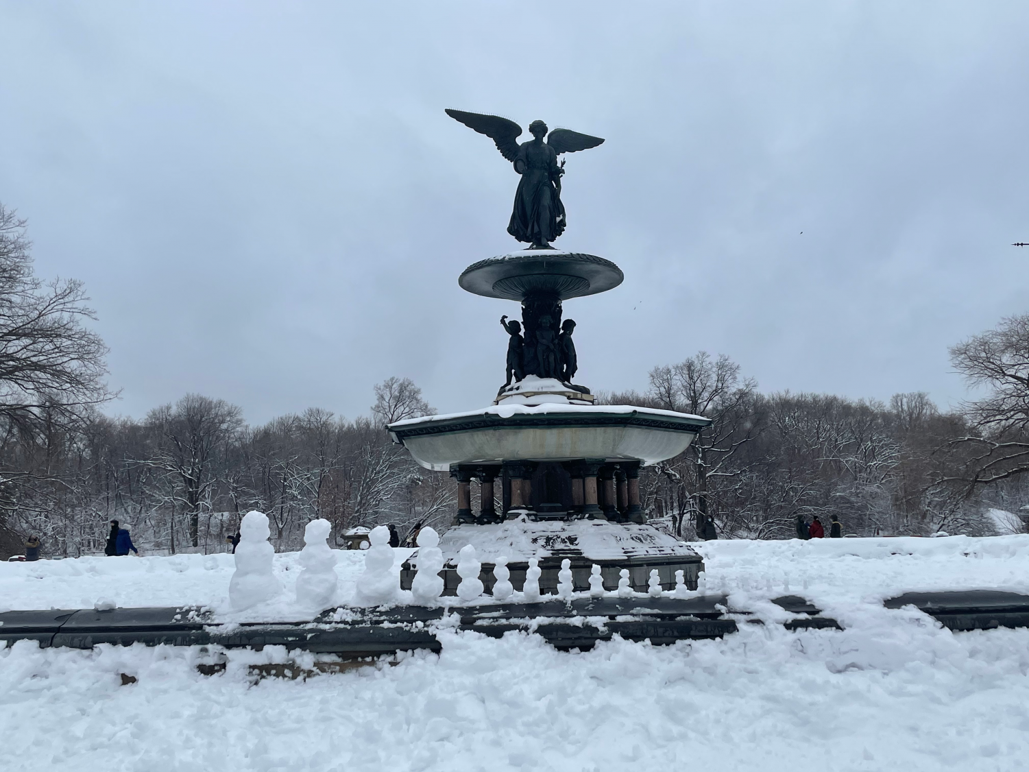 the Bethesda fountain with a series of snowmen in front of it, each getting progressively smaller
