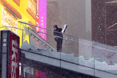 someone shoveling off the top of the stairs at Times Square