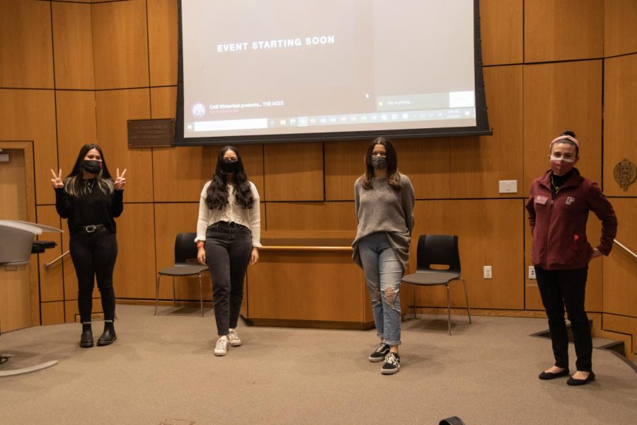 three Winterfest committee members stand with their advisor on stage