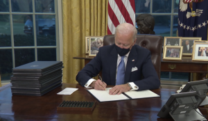 joe biden at the desk of the oval office signing an executive order