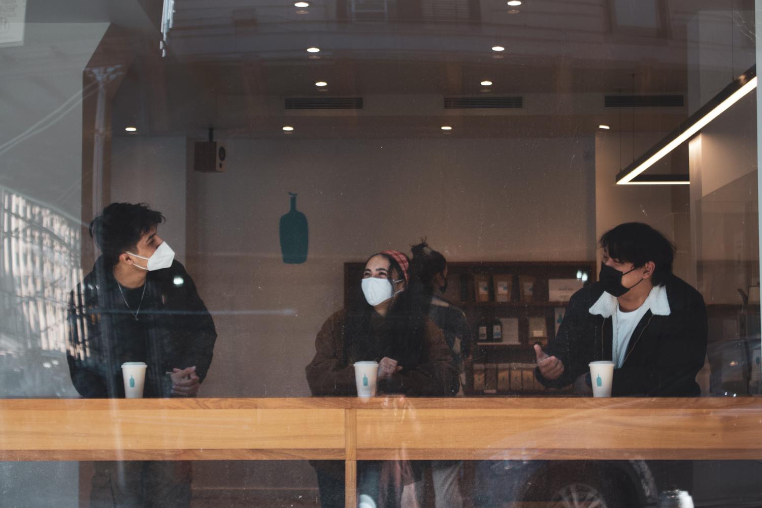 three people sitting at a coffee shop table in new york