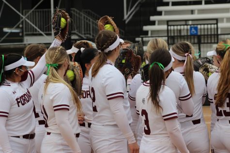 the Fordham softball team huddles up during a game