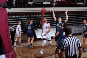 kendell heremaia makes a shot with two colonials players around her
