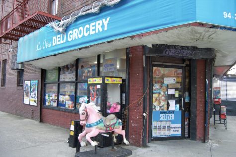 a carousel horse in front of a jackson heights grocery store