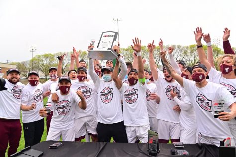 mens soccer celebrates its A10 Championship win, holding a trophy in the air