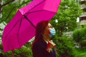 in an article about COVID-19, Angela LoCascio poses with a pink umbrella