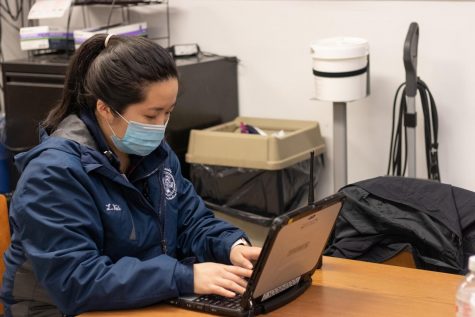 Li Ying Wei works on a laptop on her Fordham EMT job.