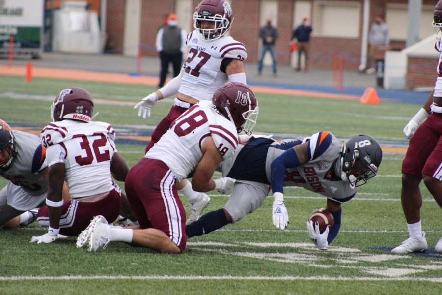 A Fordham football player tackles a Bucknell University player.