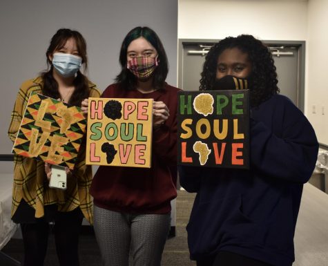 for an article about covid-19 photos, students hold their artwork reading Hope, Soul, Love from the Black History Month Paint Night