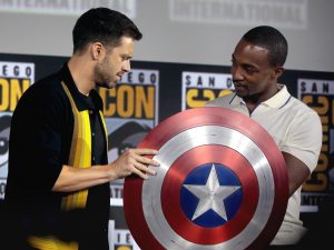 Falcon and Winter Soldier actors Sebastian Stan and Anthony Mackie stand at SDCC with the Captain America shield