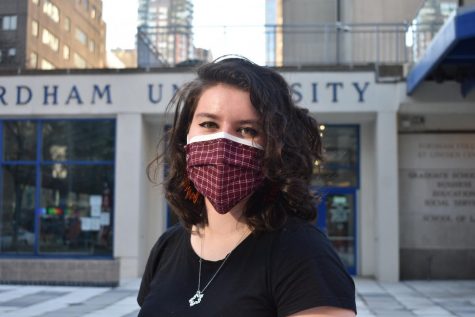 for an article about covid-19 photos, a student poses in two masks, one disposable underneath and one cloth outside, in front of Fordham Lincoln Center
