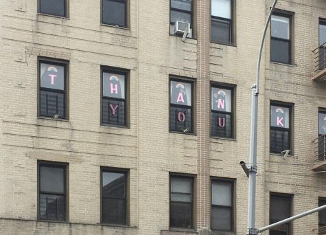 for an article about covid-19 photos, a sign reading "thank you" through sticky notes on windows, for health care workers