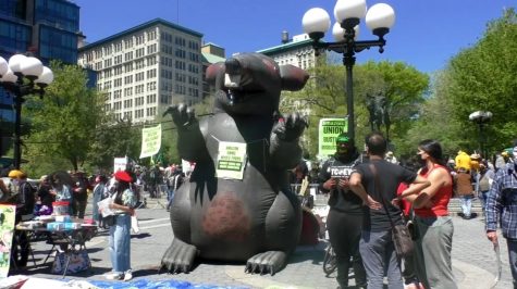 A giant inflatable rat in Union Square, next to protestors.