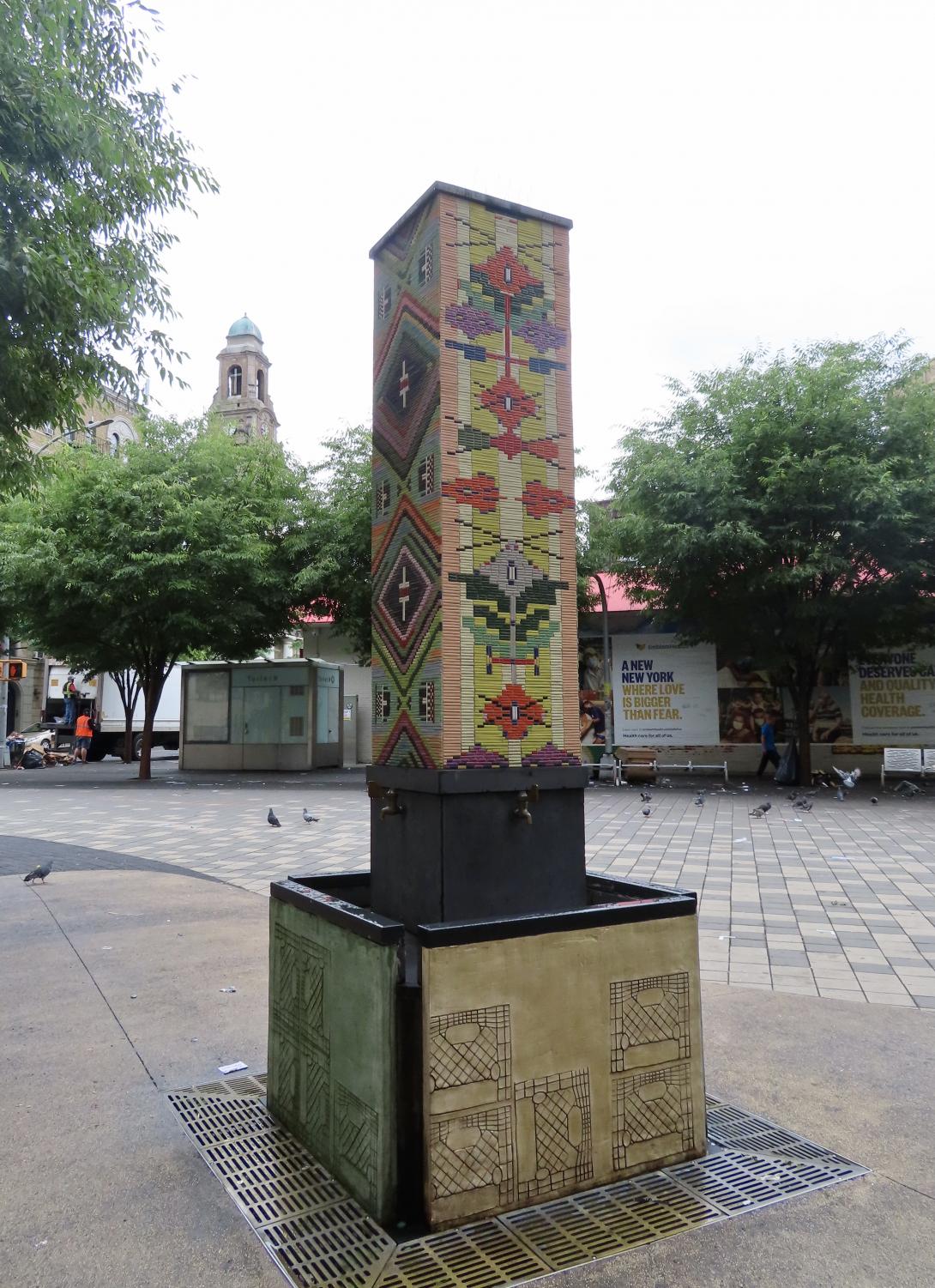 a ceramic tiled fountain, that is tall and rectangular, in a Spanish style