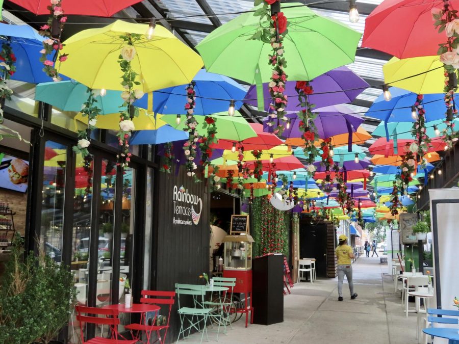 a restaurant called the Rainbow Terrace is pictured from the outside, with many umbrellas over outdoor seating